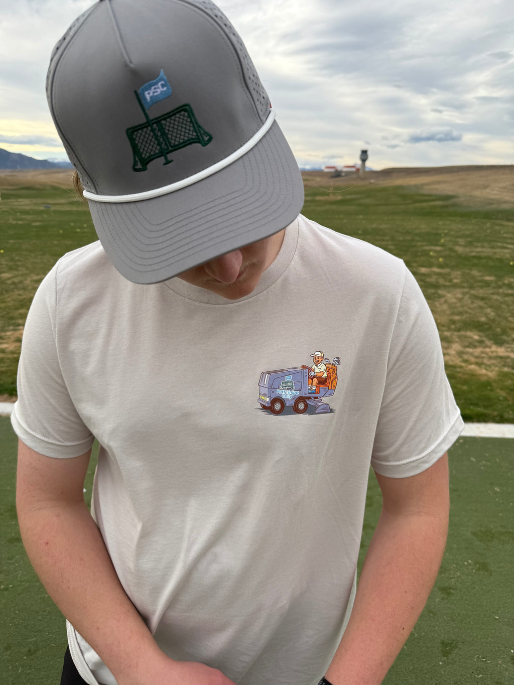 Co-founder Braden pictured at the driving range getting in some practice to kick off the golf season. Braden is wearing the Fresh Sheet Tee in Heather Dust. 