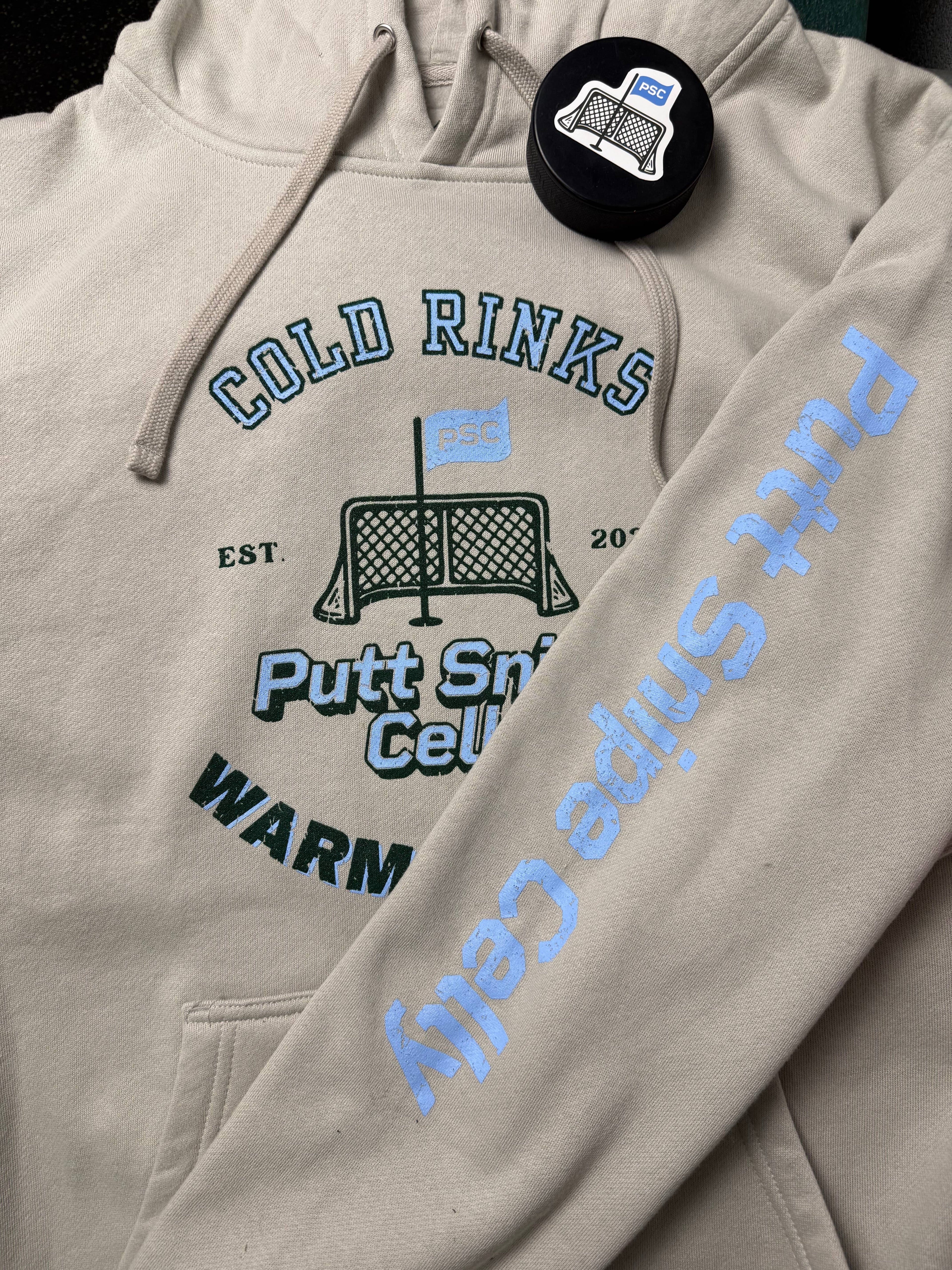 Locker Room setting featuring the Heritage design on the Smoke colored hoodie showing both the main front design and signature word mark on left sleeve from Putt Snipe Celly.